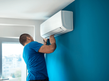 Technician installing an air conditioning unit with proper tools and safety equipment